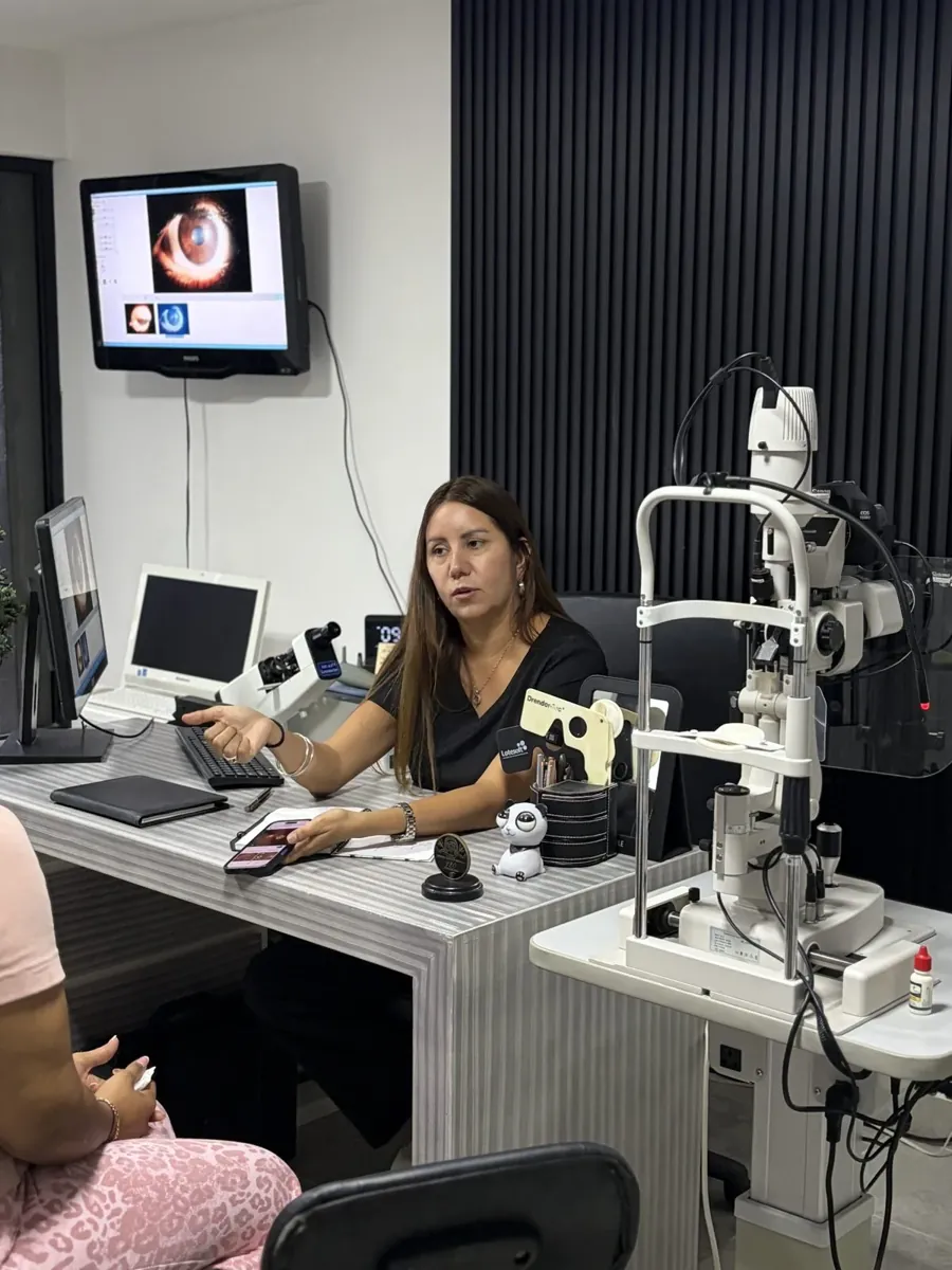 La doctora muestra a una paciente la imagen de su ojo en pantalla